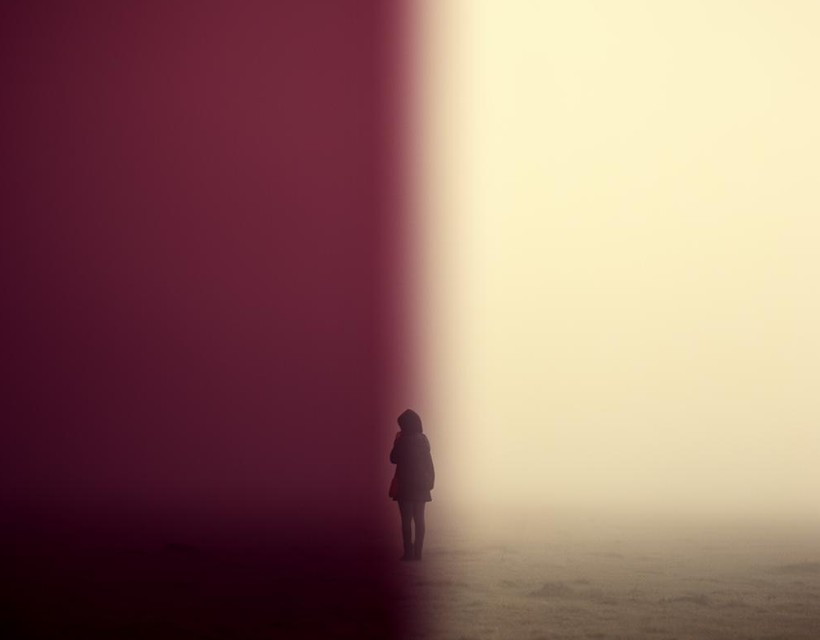 A woman standing at a crossroads on a quiet path in soft morning light